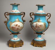 A PAIR OF 19TH CENTURY FRENCH SEVRES PORCELAIN TWO HANDLED LAMPS with ormolu masks, painted with