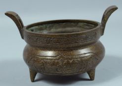 A CHINESE TWIN HANDLED CIRCULAR BRONZE CENSER. 5.5ins diameter.