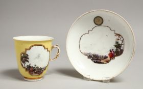 A GOOD 18TH CENTURY MEISSEN YELLOW GROUND CUP AND SAUCER painted with two panels of figures in a