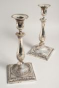 A PAIR OF GEORGE III SILVER CANDLESTICKS with acanthus leaves, bead edge and square bases. London