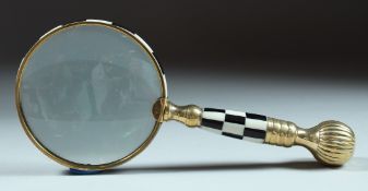 A MAGNIFYING GLASS with checkered and gilt handle.