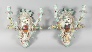 A GOOD PAIR OF MEISSEN PORCELAIN TWO BRANCH WALL SCONCES enamelled with flowers and cupids. Cross