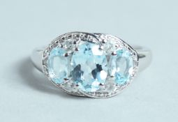 A SILVER AND AQUAMARINE THREE STONE RING.