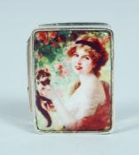 A SILVER AND ENAMEL PILL BOX with a girl and cat. 3cm long.