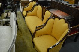 An Edwardian mahogany framed three piece suite upholstered with a gold material.