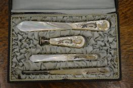 A cased four piece mother of pearl desk set.