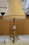 A brass tripod table lamp.