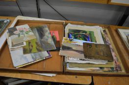 An old pine box containing unframed oil paintings.