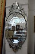 A Venetian style oval wall mirror.