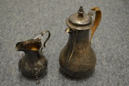 A silver hot water jug and a small silver cream jug.