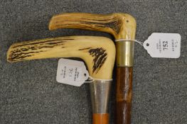 Two walking sticks with antler handles, one with silver collar.