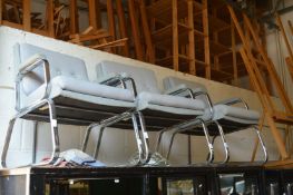 Three chrome framed office armchairs.