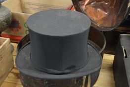 A black Japan tin hat box containing a top hat, hat internal measurements 8in x 6.5in.