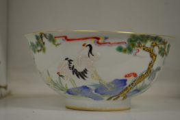A Chinese porcelain bowl decorated with storks and flowers.