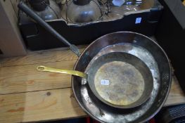Two old copper frying pans.