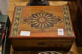 A decorative wooden box containing sewing items.