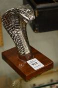 A small chrome plated model of a cobras head.