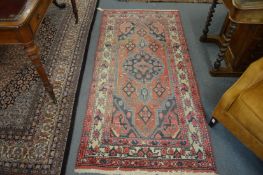 A Persian rug, pink ground with stylised decoration 195cm x 95cm.