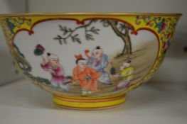 A Chinese famille jaune bowl painted with panels of children.