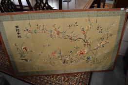 A Chinese silk embroidered panel depicting birds amongst floral branches.