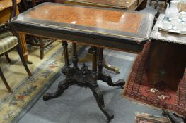 A Victorian burr wood and ebonised fold over card table on column support with splay legs.