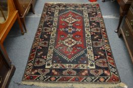 A Persian design rug, red ground with three central large motifs 190cm x 120cm.