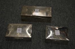 Three silver cigarette boxes.