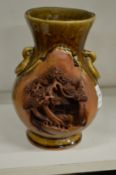 An unusual Chinese treacle glazed vase with incised and moulded landscape decoration.