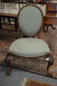 An unusual upholstered chair, possibly Irish, with oval back, over stuffed seat on profusely