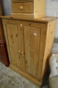 A pine two door cupboard.