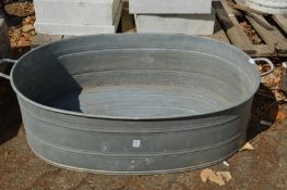 A large oval galvanised bath tub