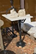 A marble topped garden table with cast iron supports.