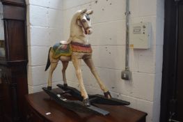 A small painted carved wood rocking horse.