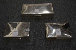 Three silver cigarette boxes.
