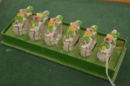 A set of six floral encrusted porcelain napkin rings.
