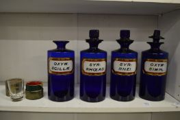 Four Bristol blue glass chemists’ bottles and a travelling medicine bottle.