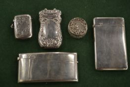 Two silver calling card cases, two vesta cases and a cast silver pill box and cover.