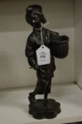 A Japanese bronzed spelter figure of a woman carrying a basket.