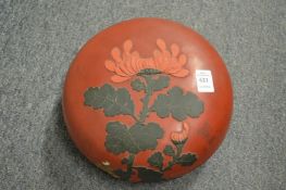 A Japanese red ground lacquer circular box and cover with applied decoration.