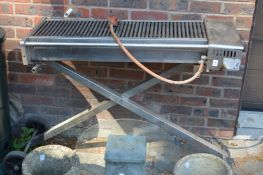 A Buffalo stainless steel professional gas barbecue with folding stand.