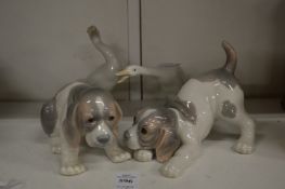 Two Lladro puppies and two Lladro geese.