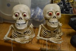 Two novelty skeleton cast iron money boxes.