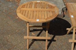A folding circular shaped hardwood coffee table.