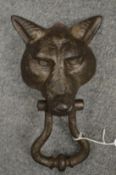 A cast iron fox head door knocker.