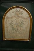 A 19th century arch shaped silk work picture, framed and glazed.