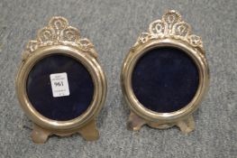 Two decorative silver circular photograph frames.