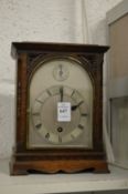 A small oak cased mantel clock with silvered dial.