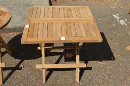 A folding square shaped hardwood coffee table.