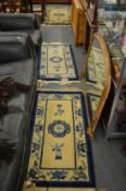 A pair of Chinese cream ground rugs with blue floral decoration and a matching larger rug, small