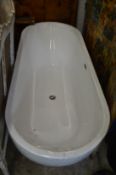 A modern resin large oval bath with side filler and central waste.